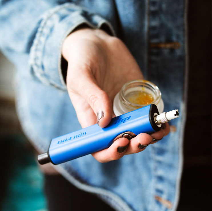 Person Holding a Vape and Jar in their Hand